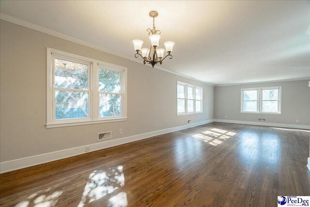 empty room featuring dark hardwood / wood-style flooring, crown molding, and plenty of natural light