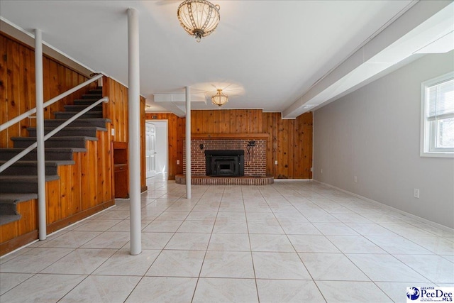 unfurnished living room with beamed ceiling, light tile patterned floors, and wood walls