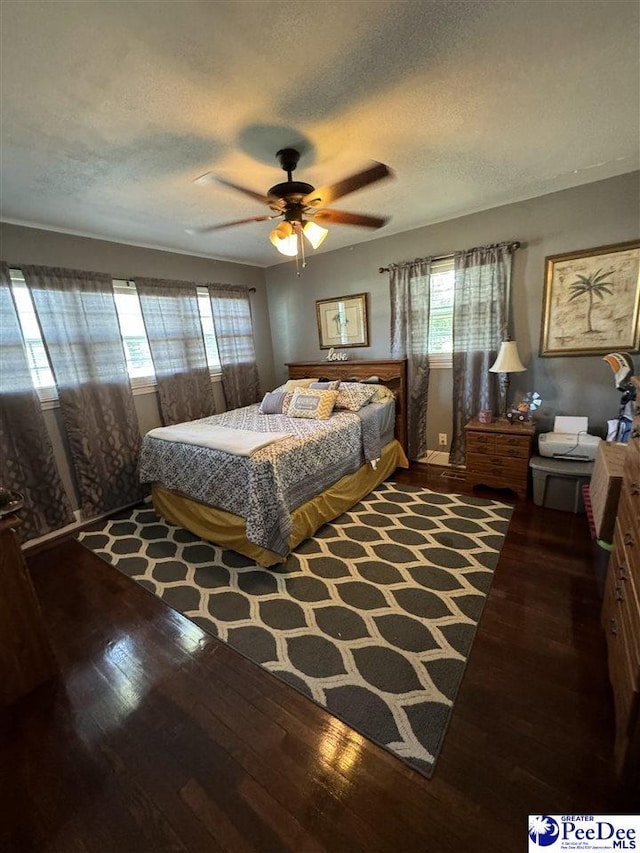 bedroom featuring hardwood / wood-style flooring, ceiling fan, and a textured ceiling