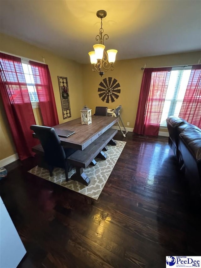 dining space with an inviting chandelier and dark hardwood / wood-style flooring