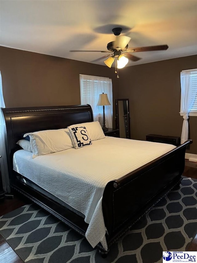 bedroom with dark hardwood / wood-style floors and ceiling fan