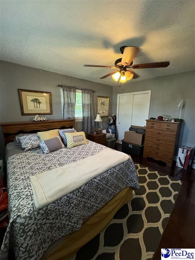 bedroom featuring a textured ceiling, ceiling fan, and a closet