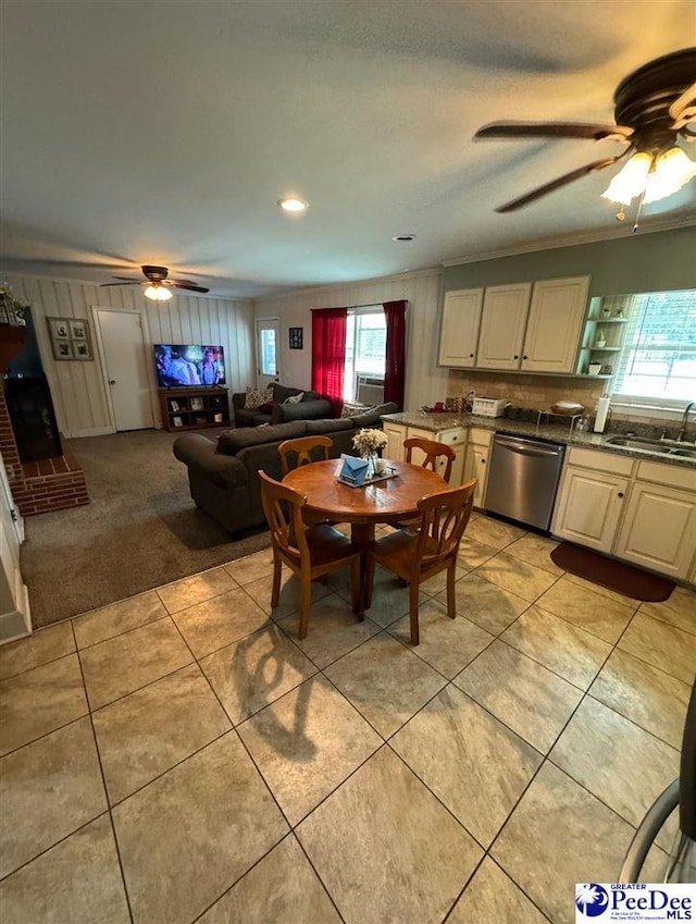 dining space featuring crown molding, sink, light tile patterned floors, and ceiling fan