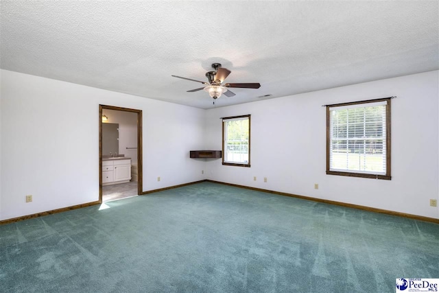 carpeted empty room with ceiling fan and a textured ceiling