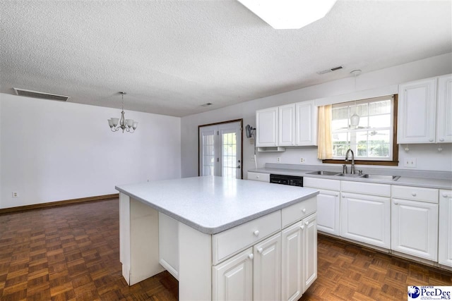 kitchen with pendant lighting, sink, a center island, and white cabinets