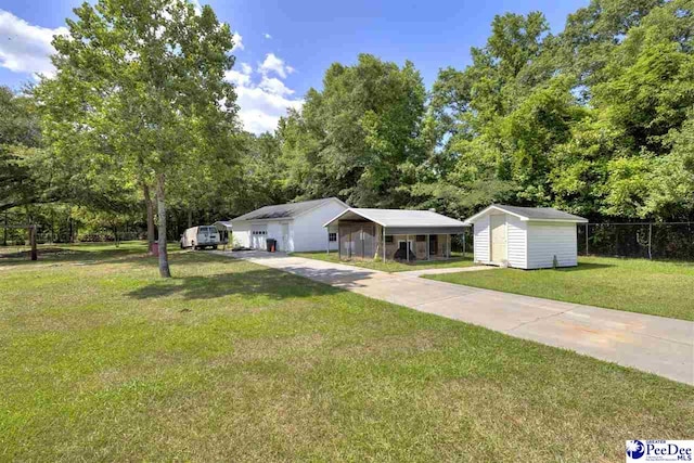 single story home featuring a carport, a front lawn, and a storage unit