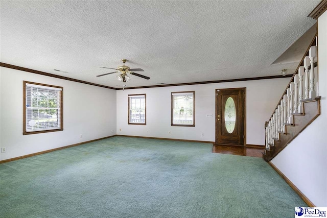 carpeted entryway with ceiling fan, ornamental molding, and a textured ceiling