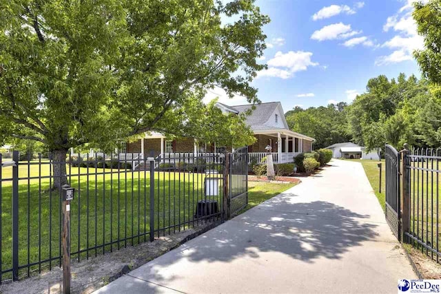 view of gate featuring a lawn and covered porch