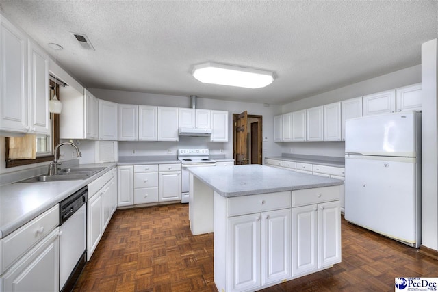 kitchen featuring sink, white appliances, a center island, dark parquet floors, and white cabinets