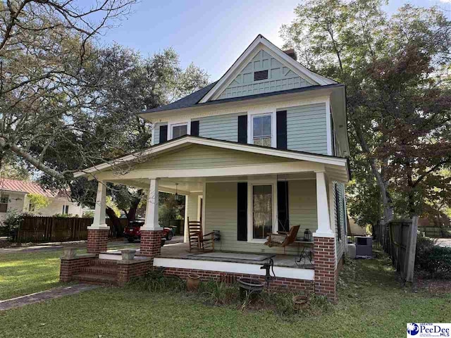 223 Third St, Cheraw, SC 29520 - view of front of home with covered porch, fence, a front lawn, and central AC unit