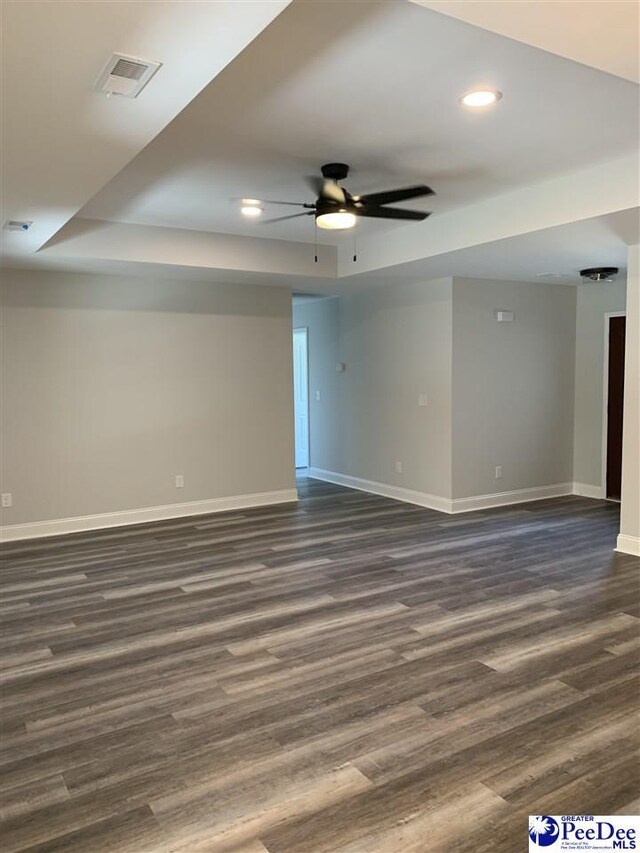 7423 E National Cemetery Rd, Florence, SC 29506 - spare room with baseboards, dark wood-style floors, recessed lighting, a ceiling fan, and a raised ceiling