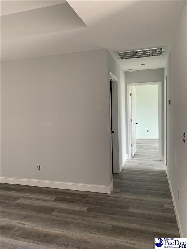 corridor featuring dark wood finished floors, visible vents, and baseboards