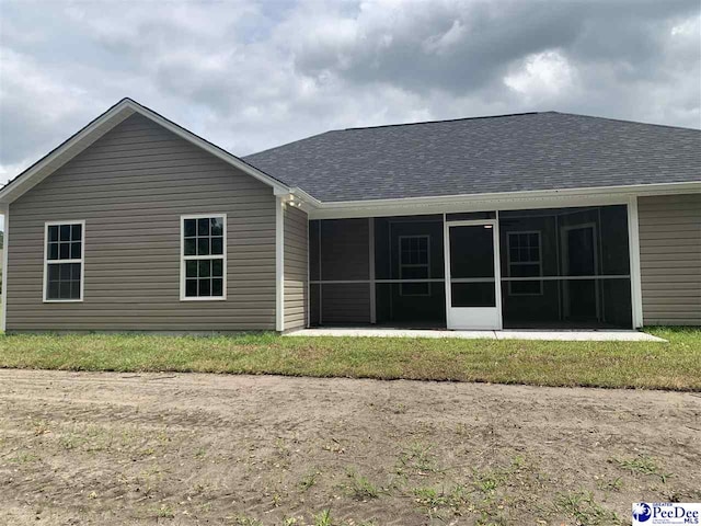 7423 E National Cemetery Rd, Florence, SC 29506 - back of property with a sunroom and a shingled roof