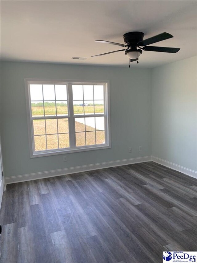 7423 E National Cemetery Rd, Florence, SC 29506 - spare room featuring baseboards, dark wood-style floors, and a ceiling fan
