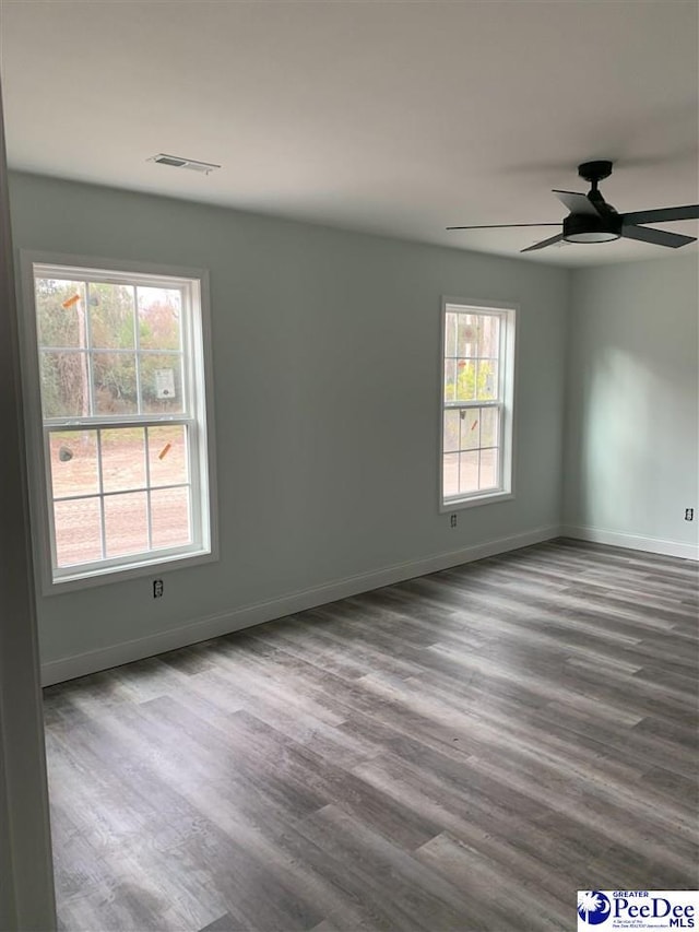 unfurnished room featuring visible vents, baseboards, and wood finished floors