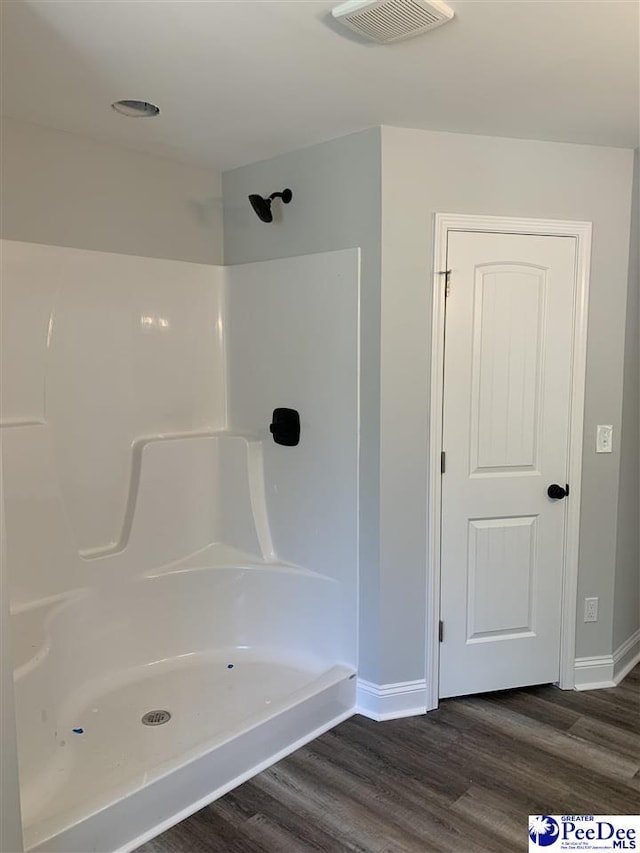 7423 E National Cemetery Rd, Florence, SC 29506 - full bath featuring wood finished floors, baseboards, and a shower