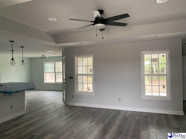 unfurnished living room with baseboards, dark wood finished floors, and a ceiling fan