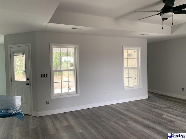 entryway with baseboards, a tray ceiling, visible vents, and dark wood-style flooring