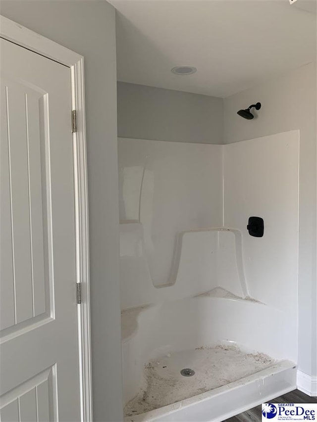 full bathroom with a stall shower and baseboards