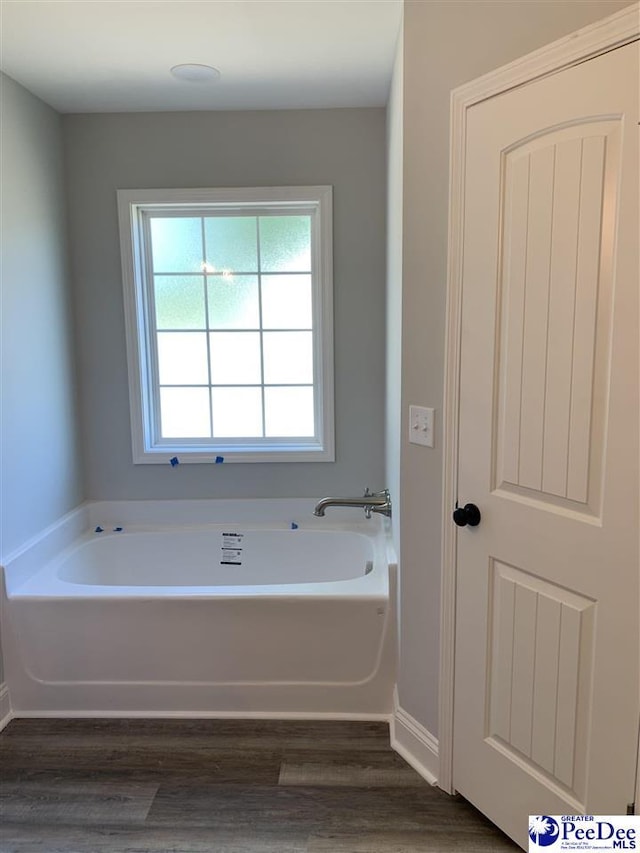 7423 E National Cemetery Rd, Florence, SC 29506 - bathroom with wood finished floors, a garden tub, and baseboards