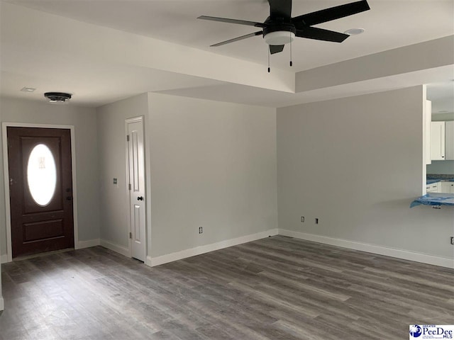 entryway featuring ceiling fan, dark wood-type flooring, and baseboards