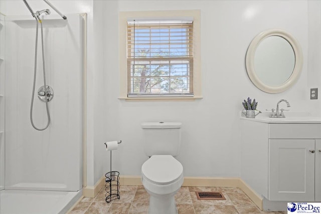 bathroom featuring vanity, toilet, and a shower