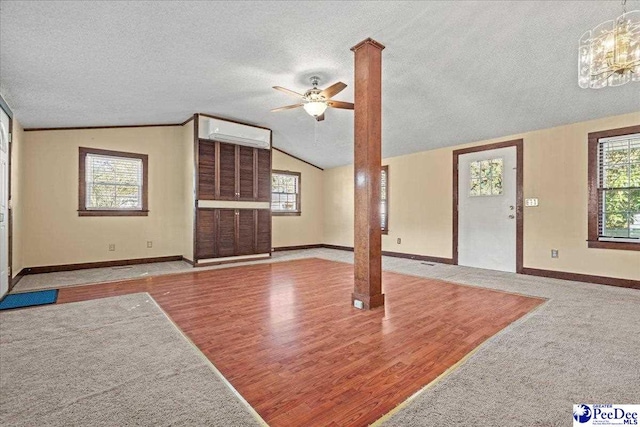 unfurnished living room featuring a healthy amount of sunlight, lofted ceiling, a textured ceiling, and light hardwood / wood-style flooring