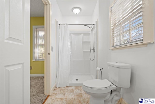 bathroom featuring curtained shower and toilet