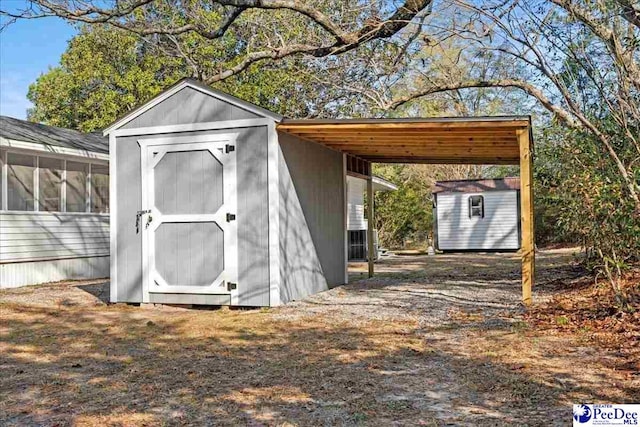 view of outdoor structure with a carport and a sunroom