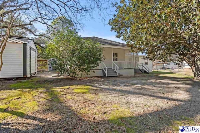 back of house with a storage shed