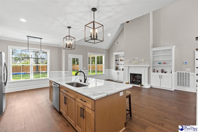 2104 Lacy St, Florence, SC 29505 - kitchen with stainless steel appliances, dark wood-type flooring, a wainscoted wall, hanging light fixtures, and light stone countertops