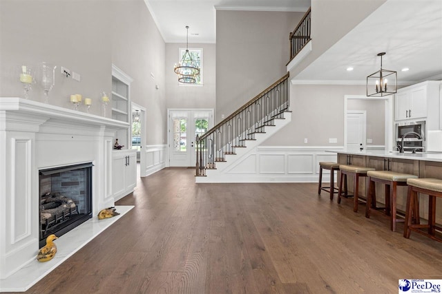 2104 Lacy St, Florence, SC 29505 - living area featuring crown molding, a chandelier, stairway, dark wood finished floors, and a decorative wall