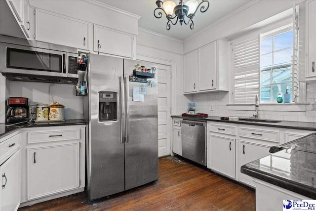 314 W Cedar St, Florence, SC 29501 - kitchen featuring dark countertops, appliances with stainless steel finishes, an inviting chandelier, a sink, and ornamental molding