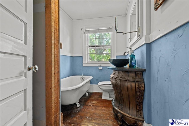 314 W Cedar St, Florence, SC 29501 - full bathroom featuring vanity, a freestanding tub, toilet, and hardwood / wood-style flooring