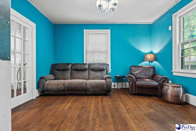 314 W Cedar St, Florence, SC 29501 - living area featuring baseboards, wood finished floors, and a notable chandelier