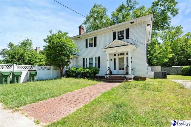 314 W Cedar St, Florence, SC 29501 - colonial-style house with fence, a chimney, and a front lawn