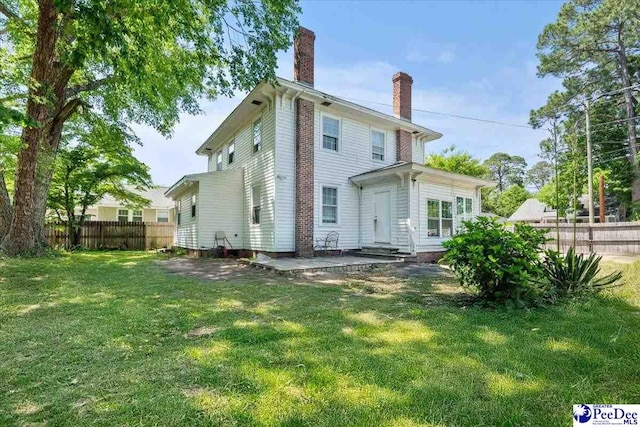 314 W Cedar St, Florence, SC 29501 - back of house with a lawn, fence, and a chimney