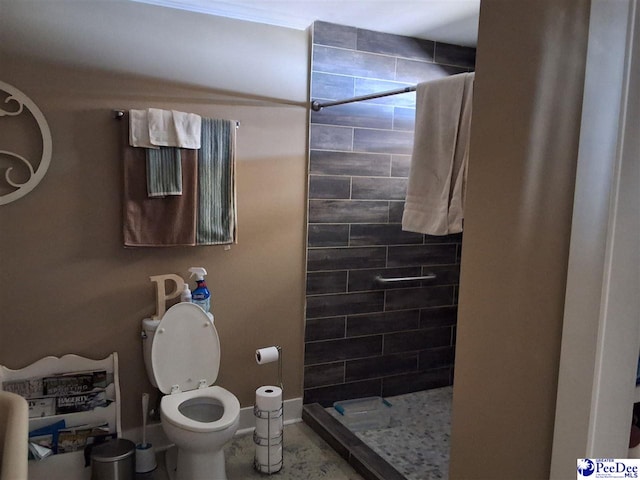 bathroom featuring tiled shower and toilet