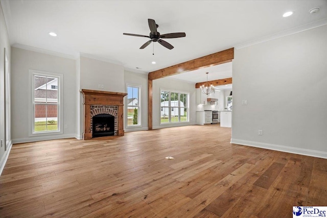 unfurnished living room with baseboards, light wood-style flooring, a fireplace, and crown molding