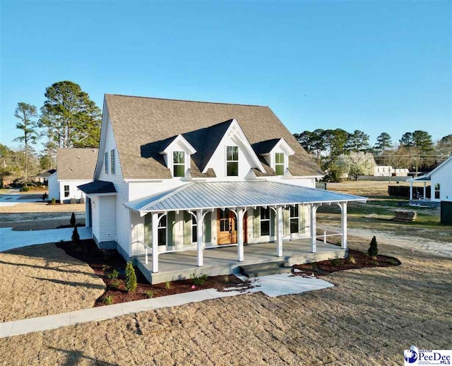 view of front of home featuring roof with shingles and a porch