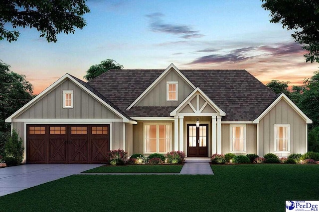 view of front of house featuring french doors, a garage, and a lawn