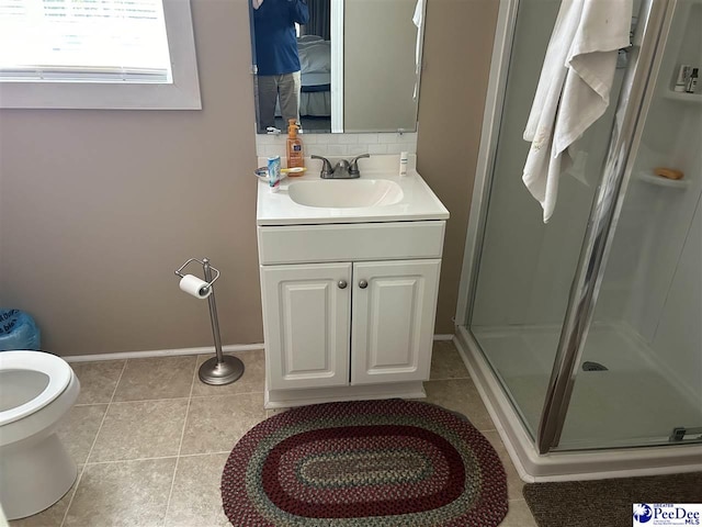 bathroom featuring tile patterned flooring, tasteful backsplash, vanity, a shower with shower door, and toilet