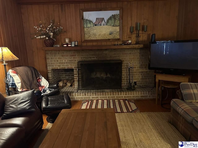 living room with a fireplace, dark hardwood / wood-style flooring, and wood walls