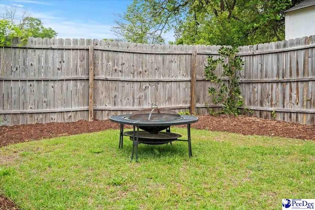 view of yard featuring a fire pit and fence