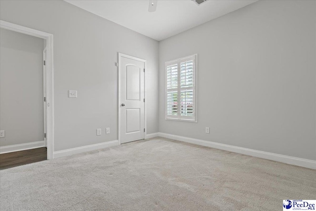 carpeted spare room with baseboards and ceiling fan
