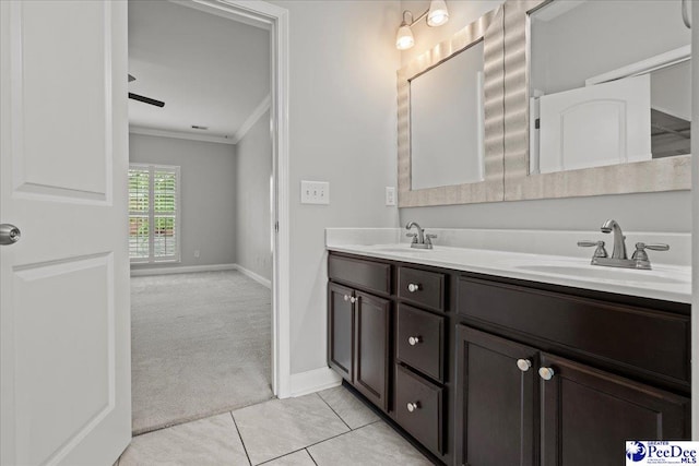 bathroom with double vanity, baseboards, a sink, and ornamental molding