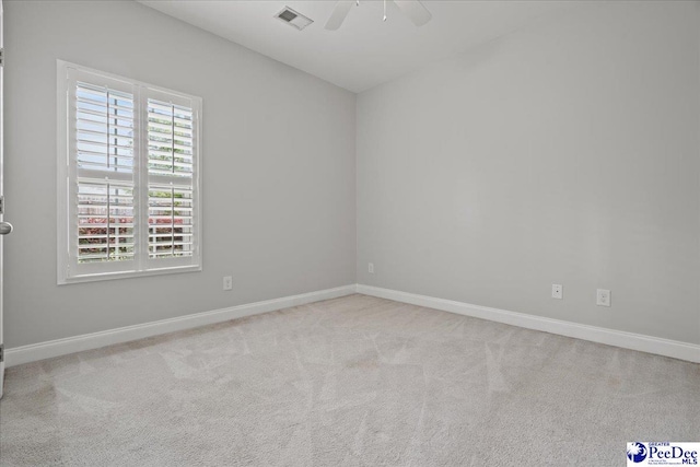 carpeted spare room featuring visible vents, baseboards, and ceiling fan
