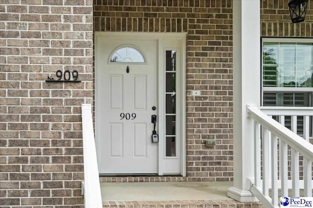 view of exterior entry with brick siding