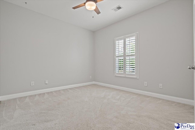 empty room with light carpet, baseboards, a ceiling fan, and visible vents