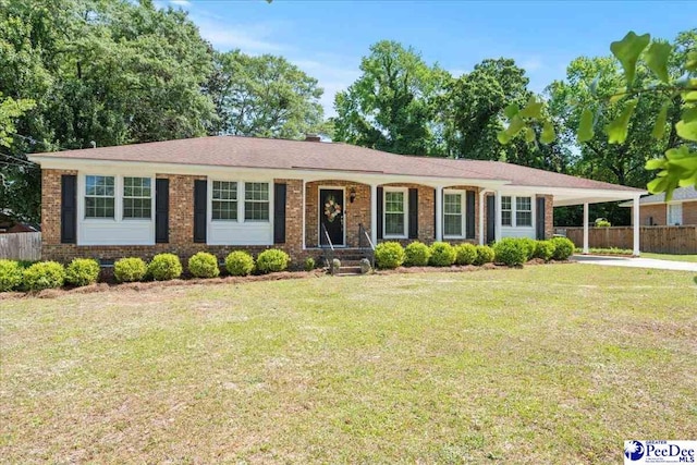 single story home featuring brick siding, fence, a carport, and a front lawn
